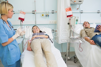 Two transfused patients looking at a nurse