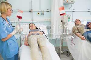 Two transfused patients looking at a nurse