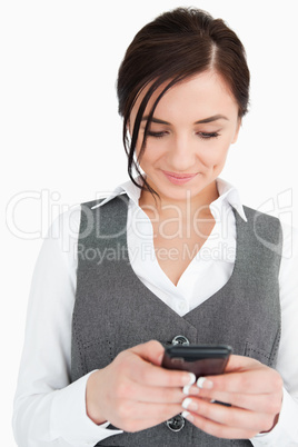 Smiling young businesswoman text-messaging