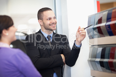 Smiling salesman pointing at a color palette
