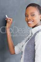 Black teacher holding a chalk while looking at camera
