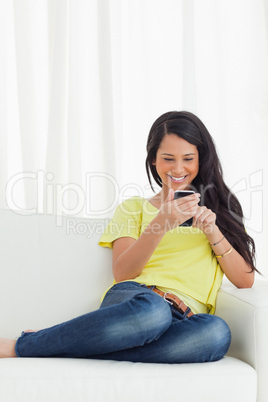 Happy Latino looking her smartphone