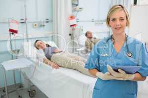 Nurse next to patients holding a clipboard