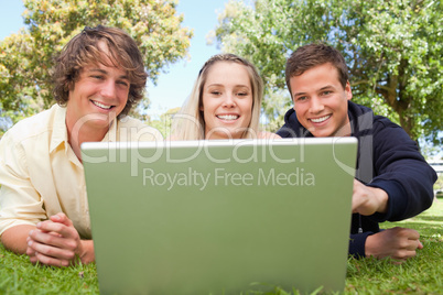 Portrait of three happy students in a park