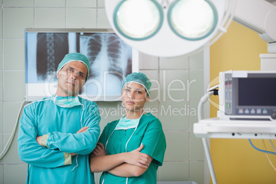 Serious surgeon and a nurse looking at camera