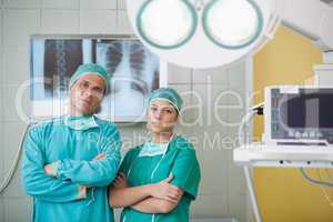 Serious surgeon and a nurse looking at camera