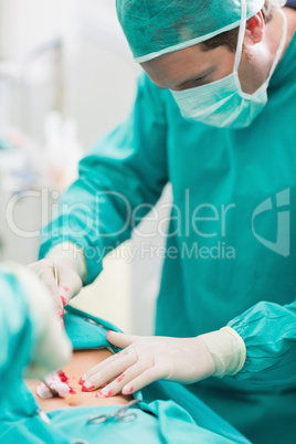 Surgeon touching at patient belly