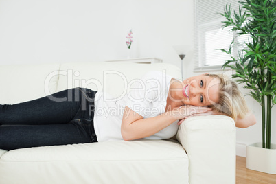 Casual woman lying on a white sofa