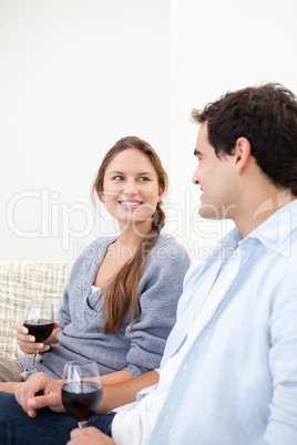 Young Couple holding a glass while looking each other