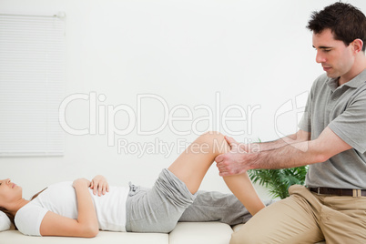 Physiotherapist sitting while massaging a knee