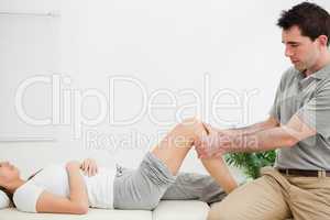 Physiotherapist sitting while massaging a knee