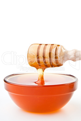 Honey dipper at horizontally  dropping a trickle of a honey