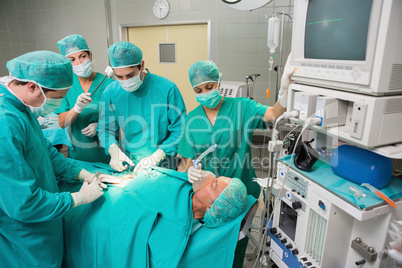 Surgical team operating a patient belly