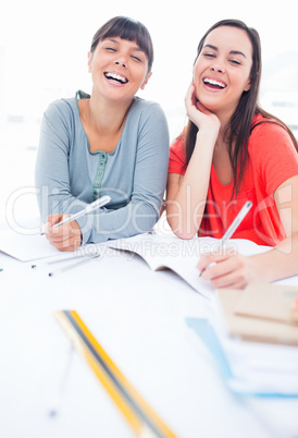 A pair of girls laughing as they look at the camera