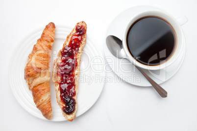 Coffee mug placed next to a croissant