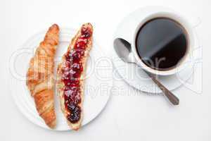 Coffee mug placed next to a croissant