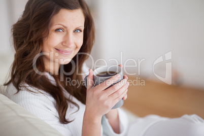 Woman smiling while holding a coffee mug