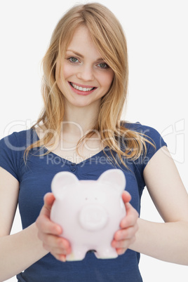Blonde woman holding a piggy bank