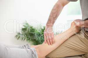 Physiotherapist pressing a leg with his fingers