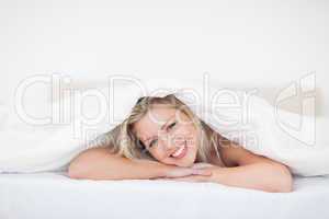 Young woman lying under a duvet