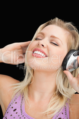 Joyful blonde woman listening to music with headphones