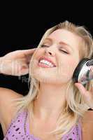 Joyful blonde woman listening to music with headphones