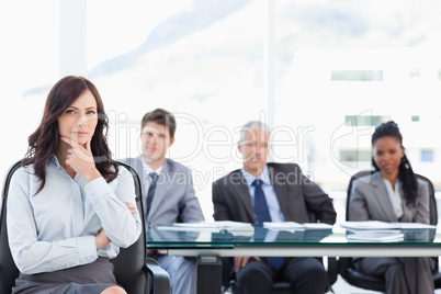 Confident businesswoman sitting with her hand on her chin while