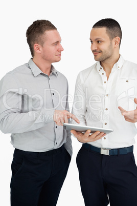 Two men together while holding a tablet computer