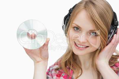 Woman holding a cd while looking at camera