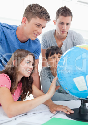 Close up of four people looking at the globe of the world