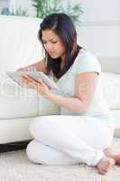 Woman holding a tactile tablet in front of a couch