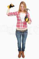 Woman standing while holding a hammer