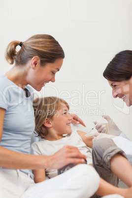 Child sitting on a bed receiving an injection
