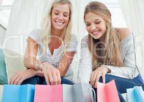 Smiling girls looking into the bags below them