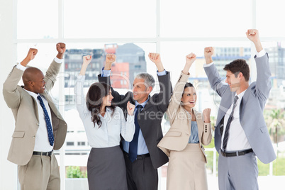 Five business people looking at each other and raising their arm