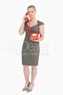 Serious woman calling with a retro phone