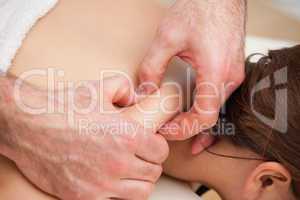 Back of woman being squeezed by hands of doctor