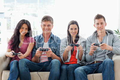 A group of friends play games while on the couch