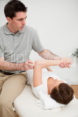 Osteopath stretching the arm of his patient