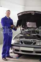 Mechanic standing while holding a computer