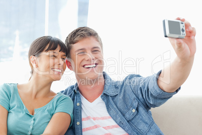 Posing couple sit together as they smile for a photo