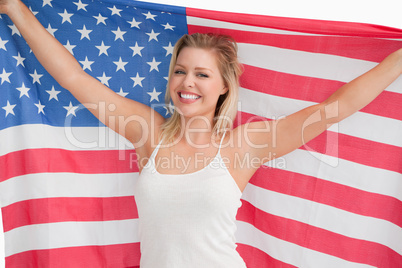 Joyful blonde woman holding the Stars and Stripes flag