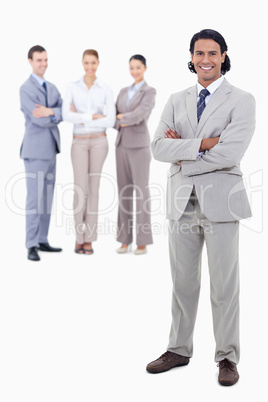 Businessman smiling and crossing his arms with happy people behi