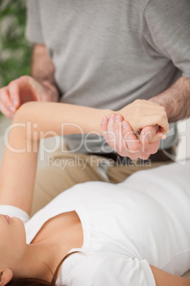 Physiotherapist moving the arm of a woman