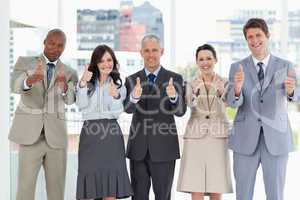 Business team showing success by putting their thumbs up