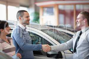 Smiling salesman shaking a customer hand