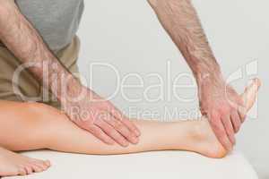 Physiotherapist touching the calf and the foot of a patient