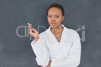 Teacher holding a chalk while looking at camera