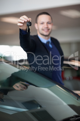 Salesman raising his arm while holding car keys