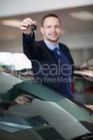 Salesman raising his arm while holding car keys